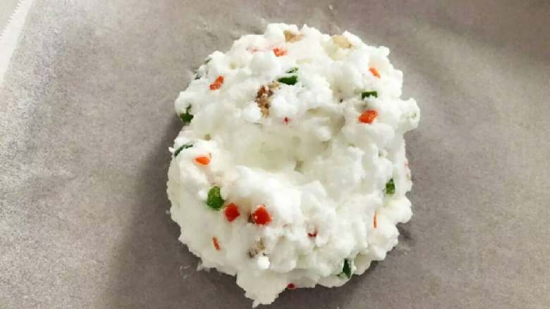 宝宝辅食:玩转鸡蛋系列之—颜值爆表,加强版火烧云,把步骤4中的蛋白混合物挖到烤盘油纸上,用刮刀或者勺子捯饬下整形,在中间挖个凹槽。