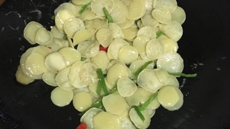青菜炒豆饼,锅中倒油加热后依次放入生姜,青椒,红辣椒,豆饼翻炒。