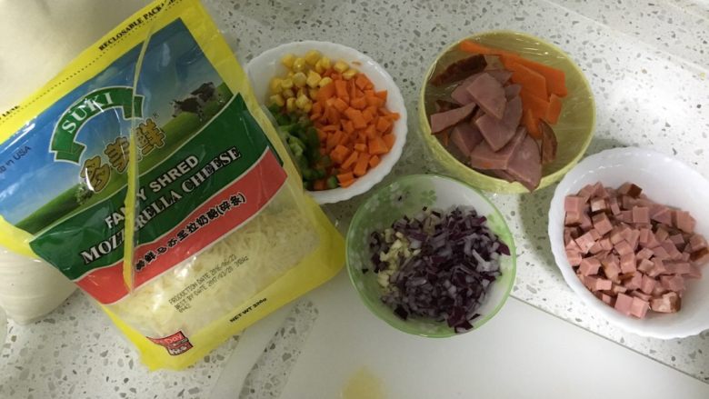 培根芝士焗饭,准备好所需食材,胡萝卜、青椒切丁,洋葱、蒜切小粒。火腿切丁。