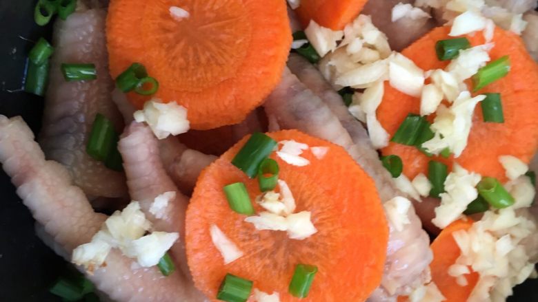 盐焗鸡爪,然后把盐焗鸡爪拿出来放入电饭煲。再放点蒜蓉和葱白，这样去焗出来的鸡爪超级香。