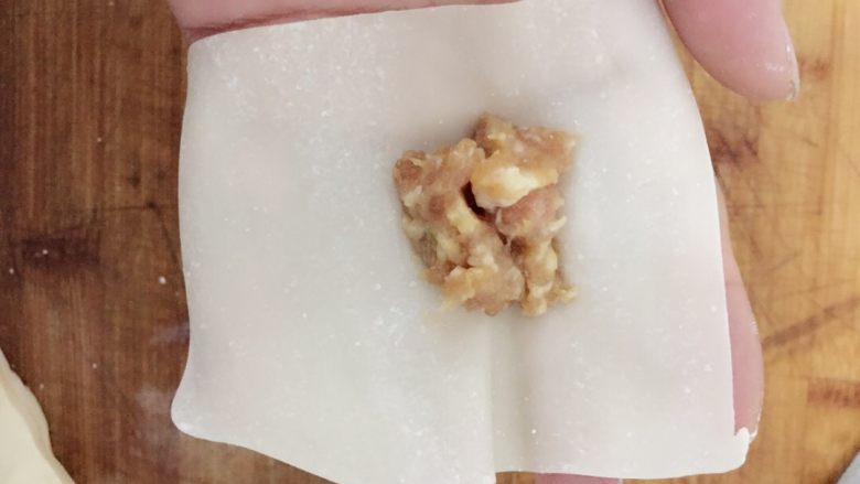 鲜肉小馄饨,小馄饨皮摊在手心，放小勺肉馅。