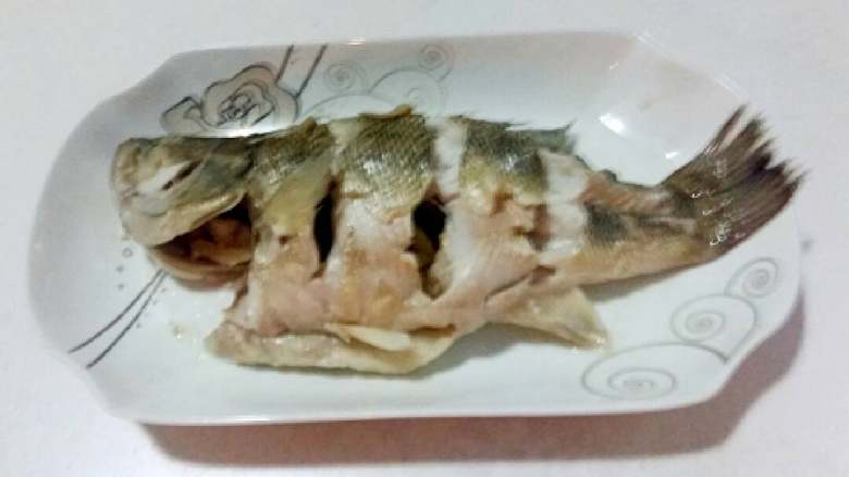 葱油鲈鱼,取出葱段,生姜片,倒出盘中的水分