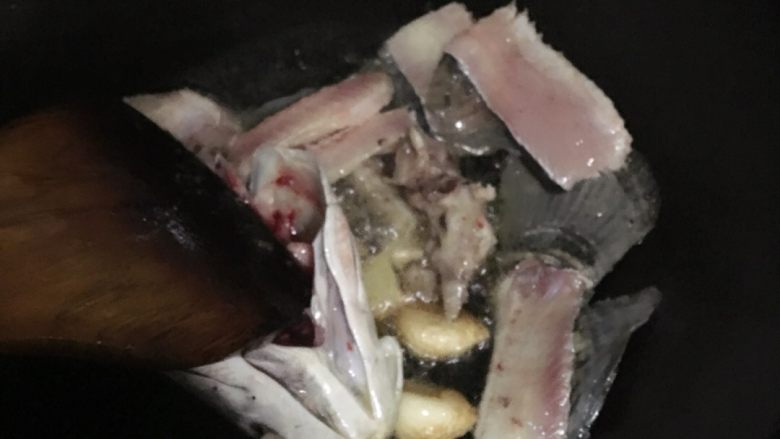 自制酸菜鱼,放入佐料,鱼骨翻炒片刻