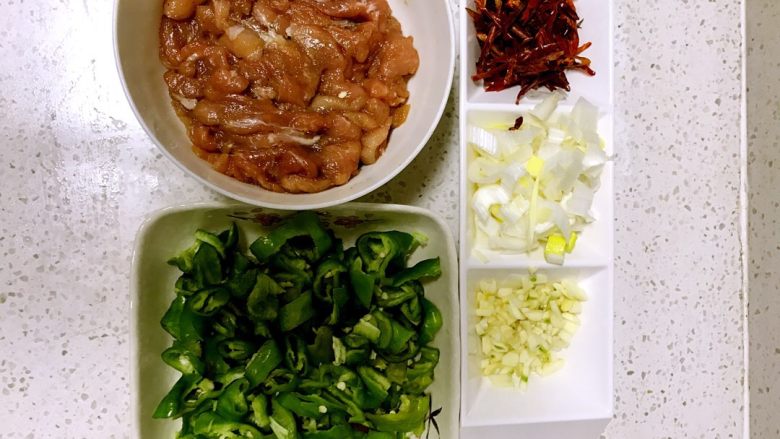 家常小炒肉,1.将肉切短片放于碗内、然后加入一勺料酒、少量水淀粉、少许生抽、一小勺花椒粉、戴一次性手套抓匀混合
腌制5分钟
2.将(葱)切小段、蒜切(小丁)、干辣椒切丝
然后盛于配菜三联小碟中
3.将洗干净的青椒滚刀切丁(盛于小方盘备用)