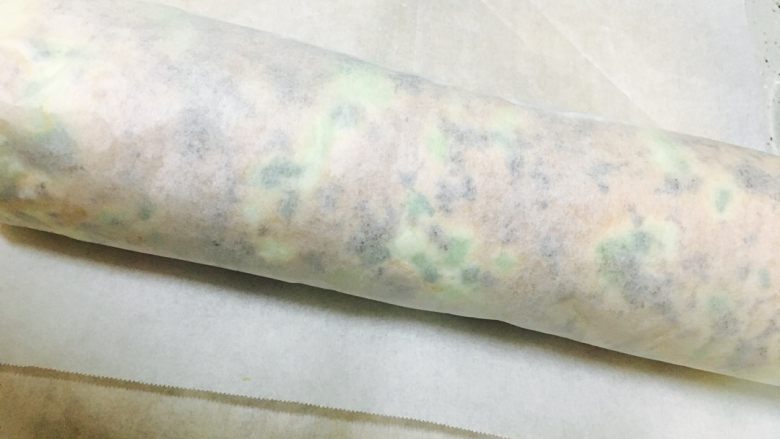 肉松卷,用擀面杖辅助着将蛋糕卷起来,卷紧用油纸固定好,放置30分钟后即可切开食用。