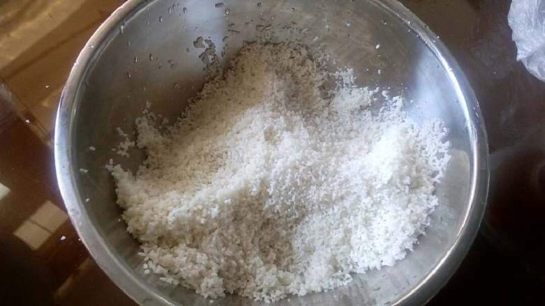 潮汕芋头糕,第二天拿出来,用个不锈钢盆装上米,再倒入900克水。芋头切成小方型颗粒,用油炒熟,洒上细盐备用。