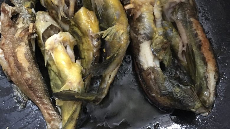 黄刺鱼萝卜干鱼煲,小心翻动,煎至表面微微金黄。