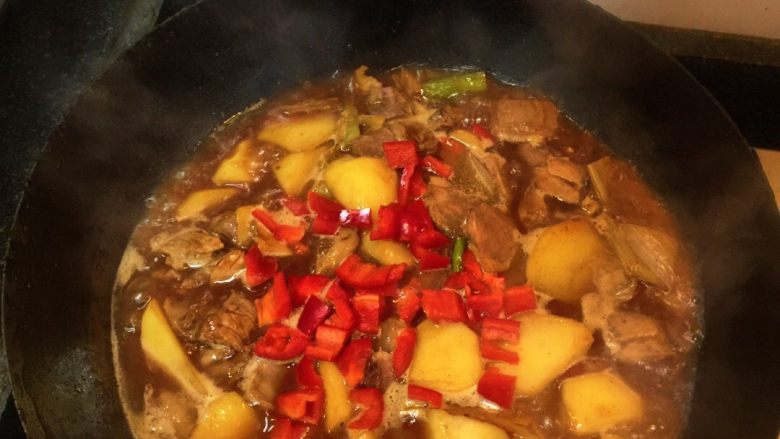 土豆烧牛肉,加入开水(或牛肉汤最好)、红椒粒中火炖煮土豆熟