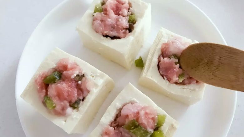 宝宝辅食:豆腐箱(肉末酿豆腐),把步骤2中备好的猪肉糜填入,和豆腐块表面平齐稍稍多出一点点即可。