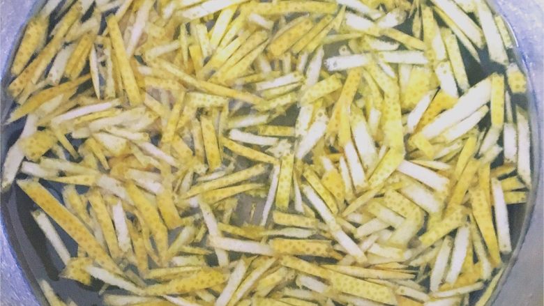 蜂蜜柚子茶(红柚版),柚子皮盐水里拿出,切丝后再泡到盐水里约15分钟。此时可用手搓几下,去苦味。