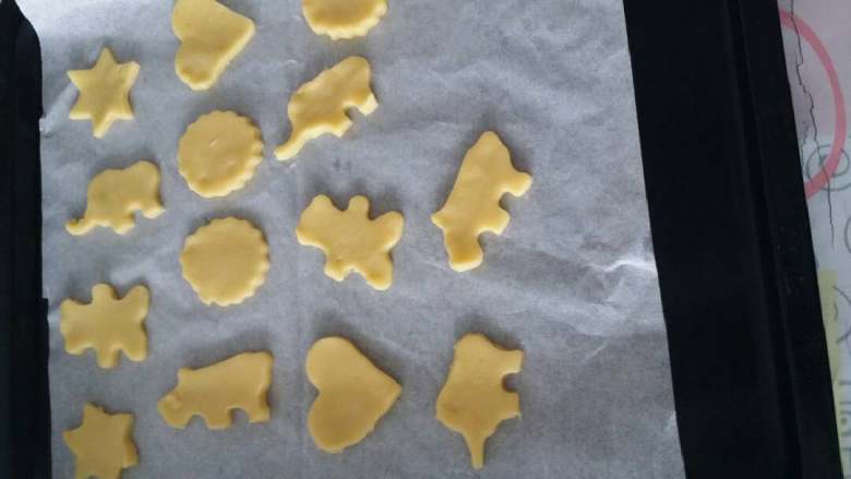 烤箱版自制小动物饼干,烤盘铺上油纸,放上饼干