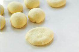 花儿豆沙面包,盖上保鲜膜松弛15分钟后用手掌按压扁。