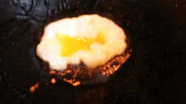 米饭蛋饺#挑战鸡蛋的100种做法#,锅里倒入一点油,用汤勺舀一勺放入锅里,全程都要小火