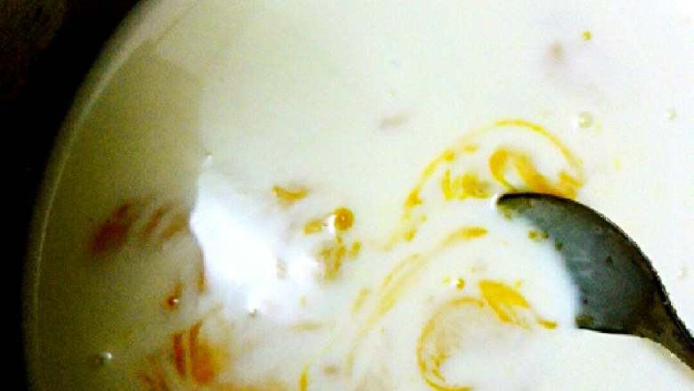 果味蛋挞#挑战鸡蛋的100种做法#,鸡蛋黄（2个蛋的蛋黄量约38g），待牛奶液冷却，将蛋黄液倒入牛奶液，搅匀