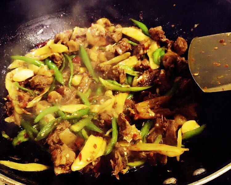 姜爆鸭,等鸭肉里的汤汁收浓,放入嫩姜片和青辣椒段翻炒至断生即可。