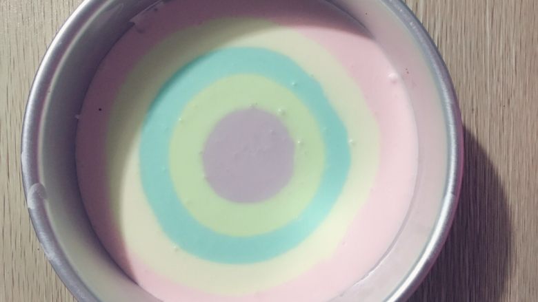 🌈彩虹酸奶慕斯蛋糕🍰,把蛋糕底从冰箱取出,按顺序加入主料,最早放的是最外层,量也是最多的,千万记住,从圆心倒,千万记住,不要抖动,不然会融合在一起,有气泡用牙签挑一一般。