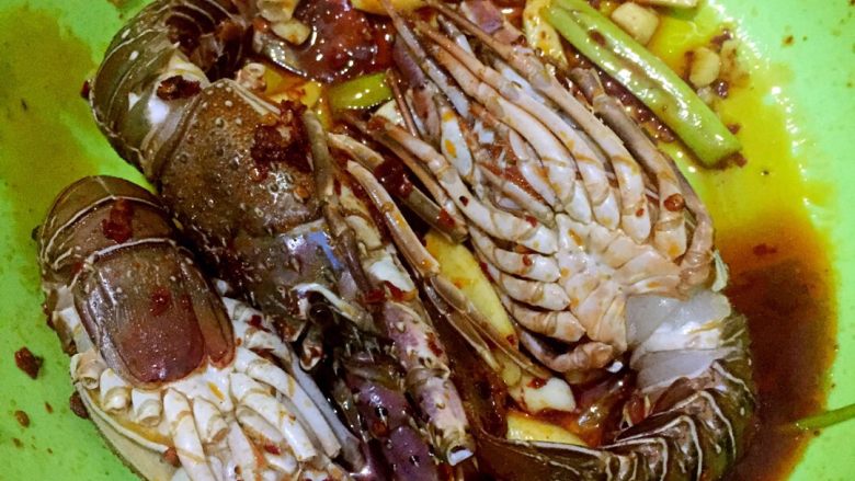 女儿的午餐,香煎小青龙虾仔,从背部剪开龙虾仔,放入蒜片、姜片、葱段一起放置在一个大盆中,加上料酒、生抽、少许盐腌制3小时左右