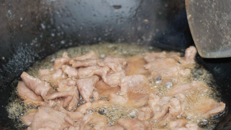 水煮肉片,锅中油烧热放入肉片炒熟后盛出。