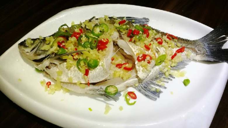 葱油鳊鱼,同时,在鱼身上撒上<a style='color:red;display:inline-block;' href='/shicai/ 37'>姜</a>、蒜、小米椒。
