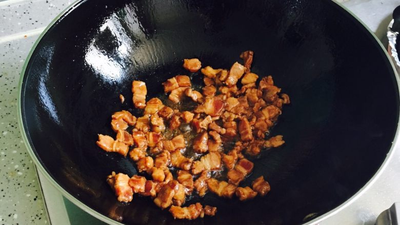 酸豆角炒肉,油锅烧热放入肉丁翻炒均匀