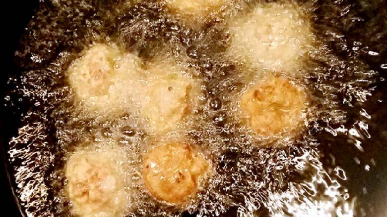 肉丸子,锅烧热倒入食用油烧到5-6成热,转中小火🔥,手沾点水取肉糜,在两只手之间像传球一样颠来颠去做圆粘合,一个个投入油锅中翻炸