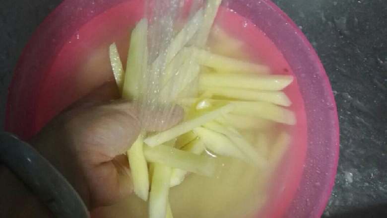 炸薯条+#食材土豆#,薯条过凉水冲洗片刻,把粉浆冲洗干净,倒入盐水中浸泡10分钟左右