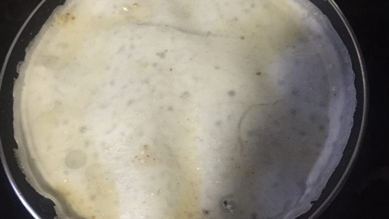 现煮锅边,用小火将不钻锅热一会，倒入肠粉稀，成饼片