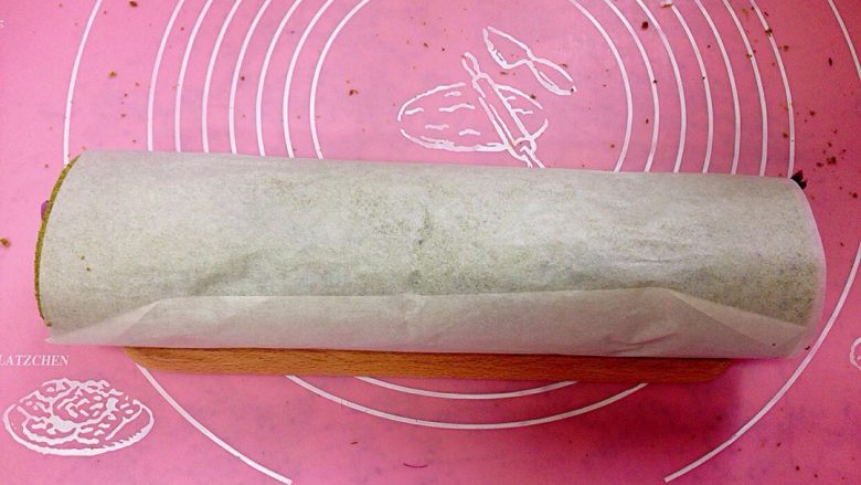香芋布丁紫薯抹茶蛋糕卷,借助擀面杖把蛋糕由内向外卷起,放冰箱冷藏至少4个小时,帮助定型。