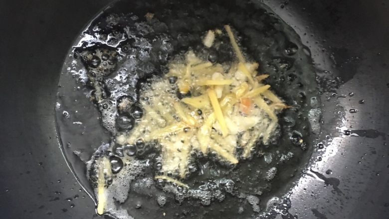海鲜炒饭,锅内倒入适量油,加热后放入姜丝和蒜末爆香。