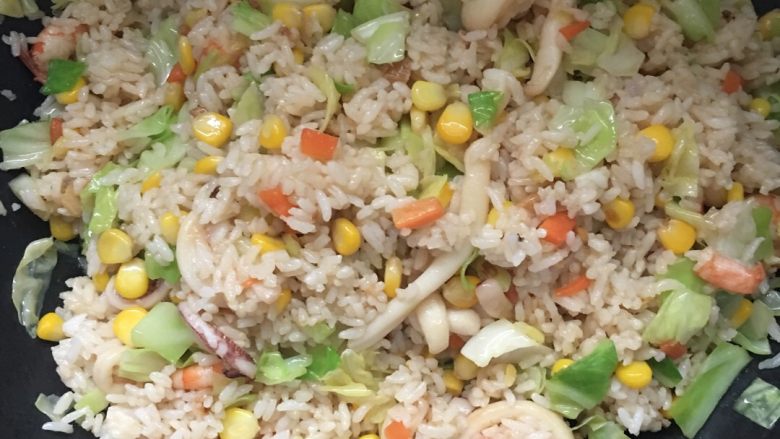 海鲜炒饭,将所有材料翻炒均匀,颜色不够深的话可以适当加入生抽炒匀。