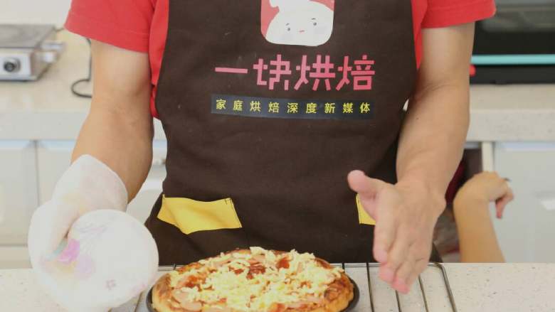 八寸火腿玉米披萨,最后铺上剩下的马苏里拉芝士,再次放入上下火210度烤箱中层烘烤5分钟左右,待芝士出现比较漂亮的一个个焦点上色即可取出