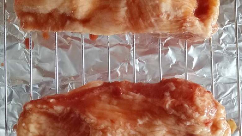 腐乳蜜汁叉烧,冷藏腌制好的肉取出,切小长条放烤网上。记得烤箱底层放上锡纸,滴落的油汁酱汁不好清洗,烤箱上下火预热180度。