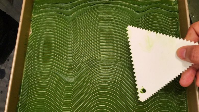 波浪抹茶蛋糕卷,拿一块锯齿刮刀,在抹茶蛋糕糊上画好波浪纹,冰箱冷藏备用