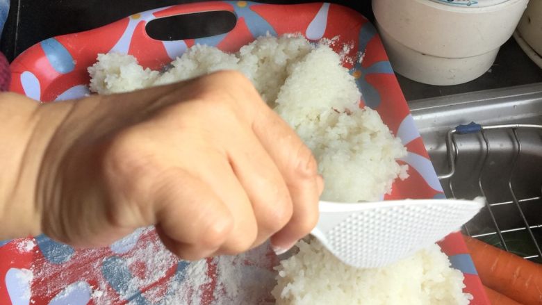 甜酒酿,铺设适量面粉后,将米饭取出晾凉至手触不烫。