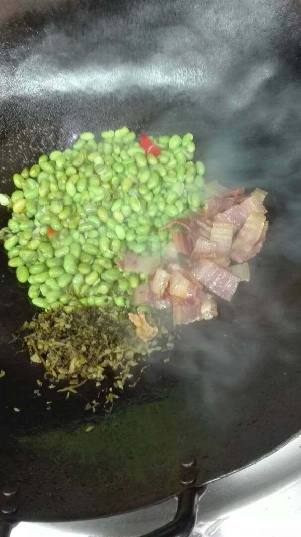 雪菜炒毛豆,净锅加猪油,放毛豆雪菜红椒片加少量水,放味精蚝油糖炒匀,下咸肉老抽即可出锅。