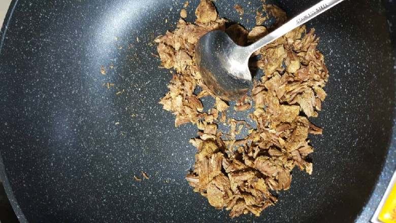 牛肉松,另起一口干净的炒锅,倒入牛肉,这时碗里会有一些牛肉汤,可以拿去煮面条或者直接喝了,牛肉放锅里炒,用铲子压碎翻炒