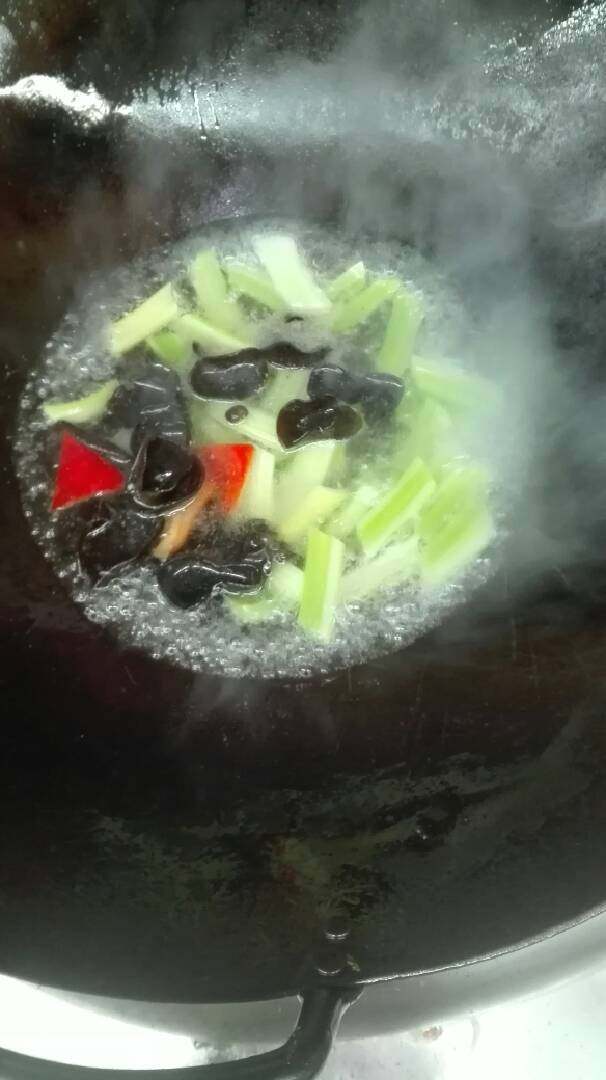 乾坤九节虾,虾头炸干摆盘,虾肉改刀腌制拉油备用,西芹木耳彩椒煸炒空出。