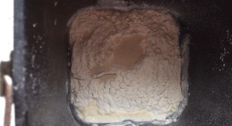 椰蓉面包,再倒入低粉和高粉,并在面粉顶部挖小坑,把酵母粉倒小坑中