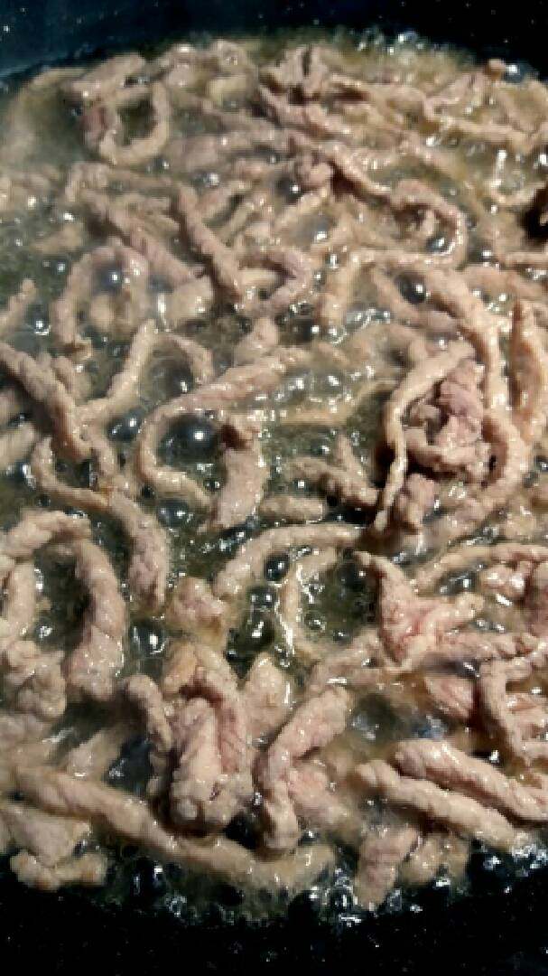 “肉炒苦瓜(家常)”绅士私房菜,锅内烧油大火烧熟肉丝后捞出。