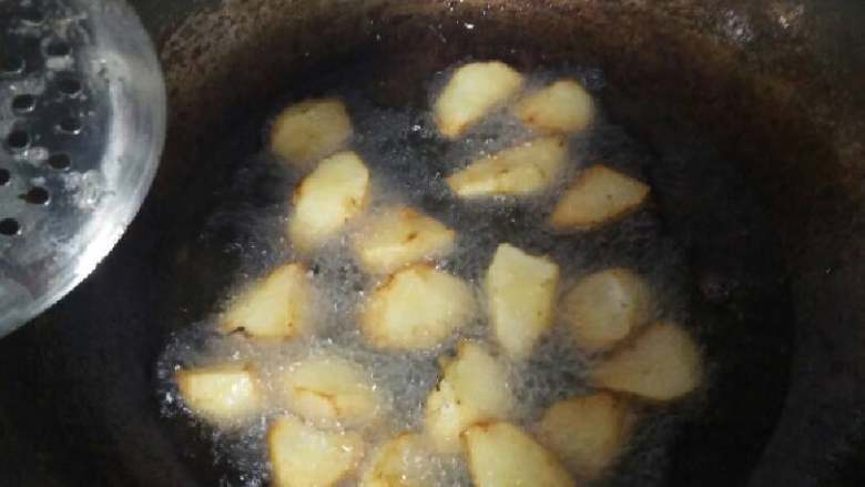 拔丝苹果,锅里热油八成热,把裹好的果块炸至发黄捞起