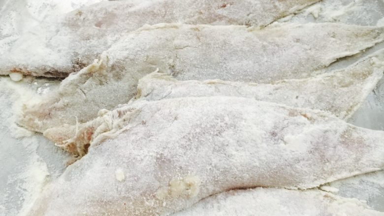 干炸海鱼🐟(王氏私房菜),取一个大一点的盘子、把面粉铺在盘底、然后把腌制好的鱼都裹上面粉……