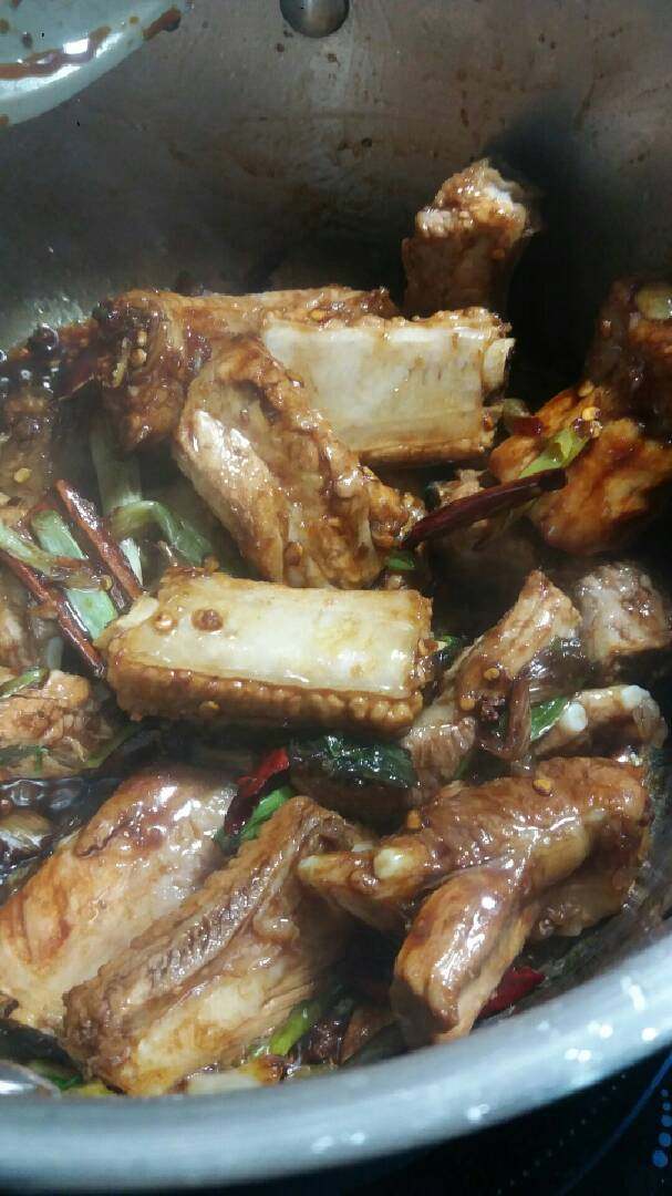 “糖醋排骨”绅士私房菜,加入排骨大火翻炒至均匀上色。
