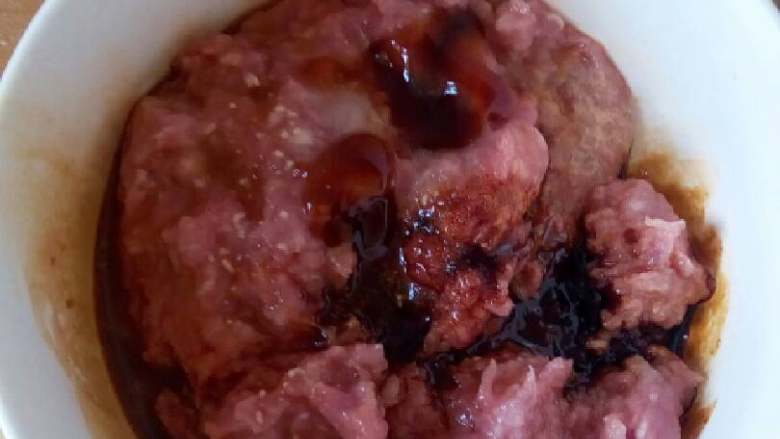 翡翠饺子,切好的肉馅放入碗里,加入2勺老抽,适量的盐,鸡精,放入一勺香油,加入一大勺的食用油,放入半碗的淀粉水