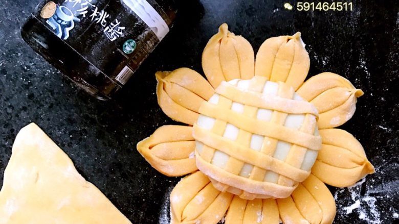 向日葵包子,取一块南瓜面擀成薄饼,用刀切成条状,如图裹在白面上面
