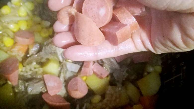 牛排骨土豆焖饭+#食材土豆#,香肠易熟,也不能太烂,煮快好时加入,继续煮