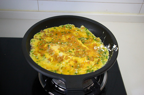 菜脯蛋,缓缓倒入打匀的鸡蛋液,中小火煎至一面定型后后翻面。