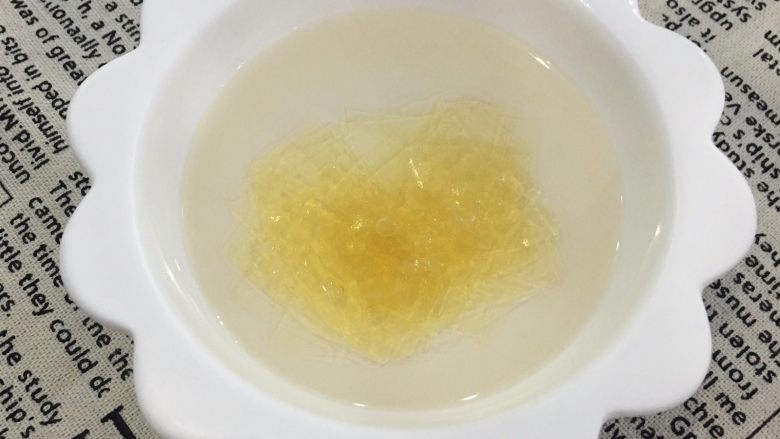 免烤芒果慕斯蛋糕,吉利丁片剪小块,加入冷开水泡软。