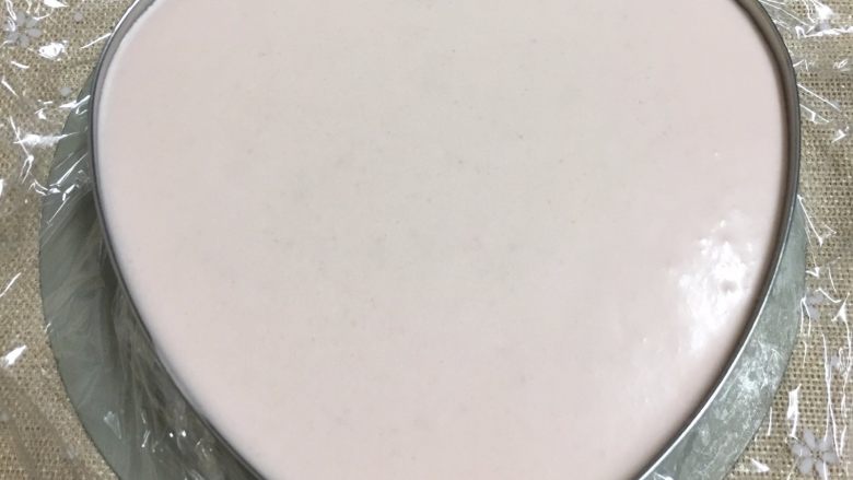 草莓慕斯蛋糕,将慕斯液倒入慕斯圈里,轻轻震几下,震出大气泡,盖上保鲜膜放入冰箱冷藏4小时以上。