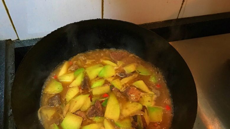 青萝卜烧牛腩,加入适量黄豆酱炒香后加入适量生抽、老抽炒匀后加入适量的水,加入少许冰糖、盐大火烧开后转小火炖煮5-7分钟