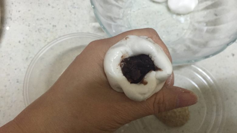 核桃豆沙麻团,把揉好糯米面团均匀分成四个剂,包入豆沙馅儿